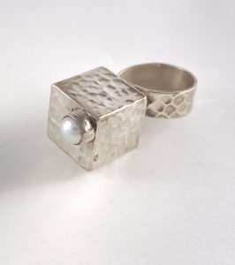 Ring that has a silver square box and pearl on the top view 1