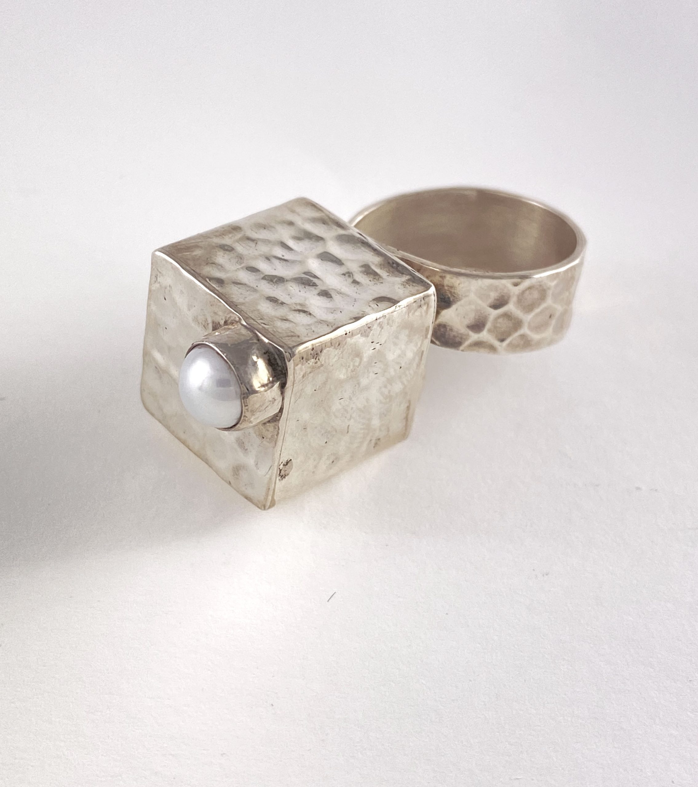 Ring that has a silver square box and pearl on the top view 1