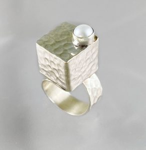 Ring that has a silver square box and pearl on the top view 3